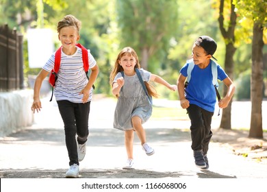 Cute Little Schoolchildren Running Outdoors