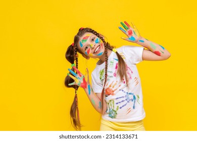 A cute little schoolgirl with stained hands in paint, A child is engaged in drawing, a girl has stained her hands in paint, A girl shows her hands that she has stained in paint. - Powered by Shutterstock