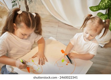 Cute little sisters are painting on table. Preschooler, 4 and 8 years child in living room. Small girl kids doing homework. Home schooling concept - Powered by Shutterstock