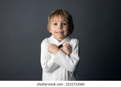 Cute little toddler boy, showing  I LOVE YOU gesture in sign language on gray background, isolated image, child showing hand sings 