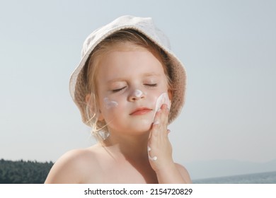 Cute Little Toddler Girl Applying Sunscreen Protection Cream On The Beach. Sun Blocking Lotion For Protecting Baby From Sun During Summer Vacation. Children Skin Care During Travel Time.