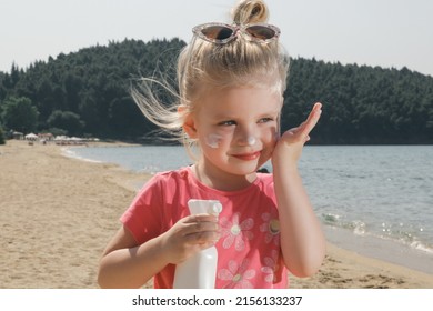 Cute Little Toddler Girl Applying Sunscreen Protection Cream On The Beach. Sun Blocking Lotion For Protecting Baby From Sun During Summer Vacation. Children Skin Care During Travel Time.
