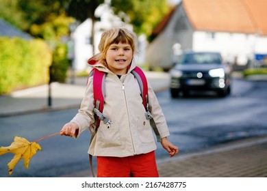 Cute little toddler girl on her first day going to playschool. Healthy happy child walking to nursery school. Kid with backpack going to day care on the city street, outdoors