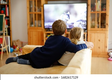 Cute Little Toddler Girl And School Kid Boy Watching Animal Movie Or Movie On Tv. Happy Healthy Children, Siblings During Coronavirus Quarantine Staying At Home. Brother And Sister Together. No Face