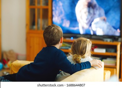 Cute Little Toddler Girl And School Kid Boy Watching Animal Movie Or Movie On Tv. Happy Healthy Children, Siblings During Coronavirus Quarantine Staying At Home. Brother And Sister Together. No Face