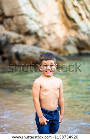 Cute little boy toaching the water with his feet.