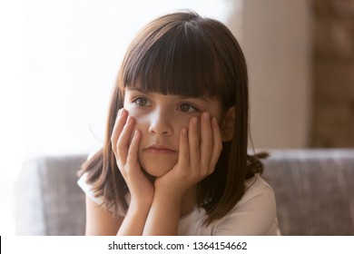 Cute lonely little orphan girl sitting on couch alone adoption childship and foster concept. Preschool depressed daughter feels unsure concerned hiding problems, psychological trauma, secretive child - Shutterstock ID 1364154662