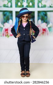Cute long haired girl in blue hat - children beauty and fashion concept