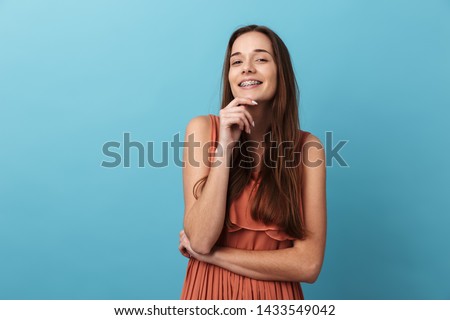 Cute lovely young girl standing isolated over blue background, posing