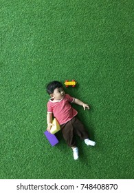 A Cute Malay Baby Wearing A Red Shirt Playing On A Green Background