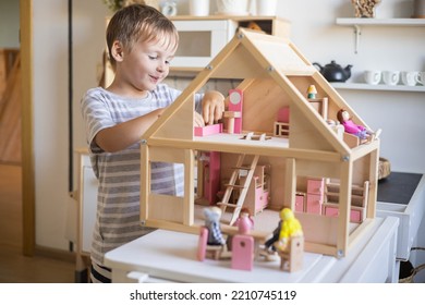 Cute Male Kid Playing Toy Doll House Characters With Interior Furniture Montessori Wooden Eco Friendly Material Early Development Educational Game. Child Boy With Natural Playthings Construction