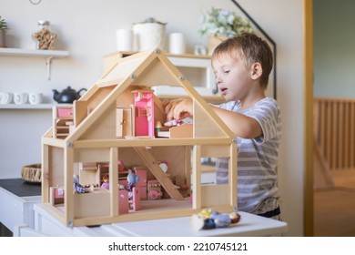 Cute Male Kid Playing Toy Doll House Characters With Interior Furniture Montessori Wooden Eco Friendly Material Early Development Educational Game. Child Boy With Natural Playthings Construction