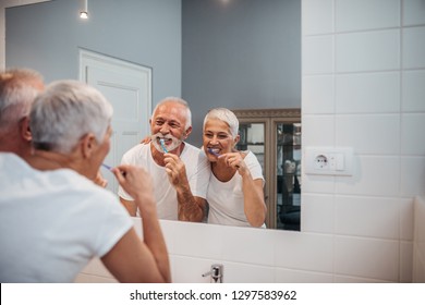 Cute Mature Couple Brushing Teeth