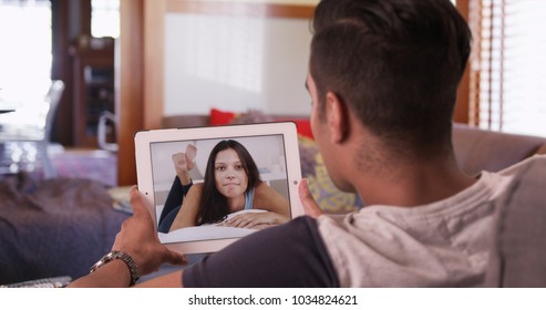 Cute Millennial Couple Video Chatting Or Having A Facetime Conversation With His Girlfriend On Tablet Computer