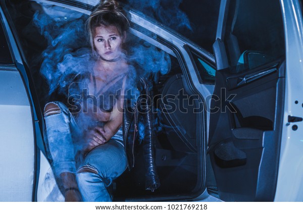 cute model sitting in a car full of smoke, smoke\
photography, young girl in a\
car