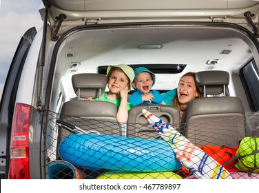 Cute Mom With Sons Peeking From Behind A Car Seat