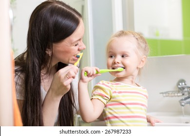 Cute Mom Teaching Child Teeth Brushing In Bathroom