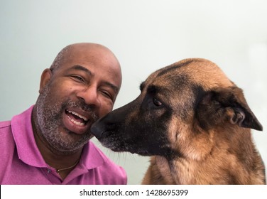 Cute Moment Between An African American Man And His German Shepherd Dog Who Is Giving Kisses