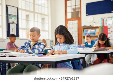 Cute multiethnic pupils writing at school desks in classroom at elementary school. Focused children writing during a dictation exercise in primary class. Middle eastern schoolgirl writing in classroom - Powered by Shutterstock