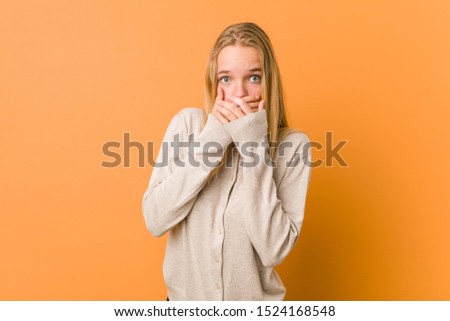 Cute and natural teenager woman shocked covering mouth with hands.