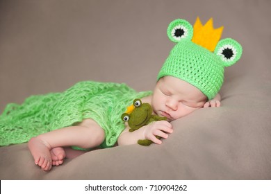 Cute Newborn Baby In A Frog Costume With Plush Toy Frog