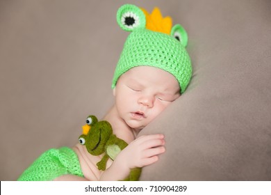 Cute Newborn Baby In A Frog Costume With Plush Toy Frog