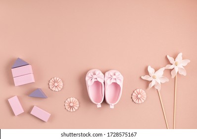 Cute Newborn Baby Girl Shoes With Festive Decoration Over Pink Background. Baby Shower, Birthday, Invitation Or Greeting Card Idea