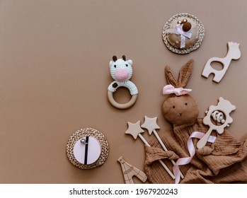 Cute Newborn Baby Items With Decoration Over Brown Background. Baby Shower, Birthday, Invitation Or Greeting Card Idea. Top View Flat Lay 