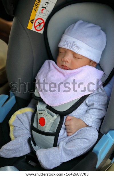cute newborn baby sleeping in car seat safety\
belt lock protection drive road\
trip