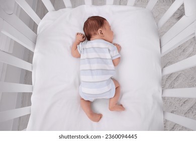 Un lindo recién nacido durmiendo en una cuna en casa, vista superior. Tiempo de espera