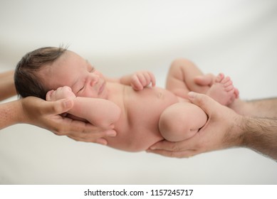 Cute newborn baby sleeps in the hands of parents protected and safe - happy family moments for mom and dad - Powered by Shutterstock