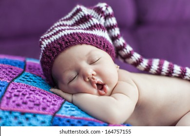 Cute newborn baby sleeps in a hat
