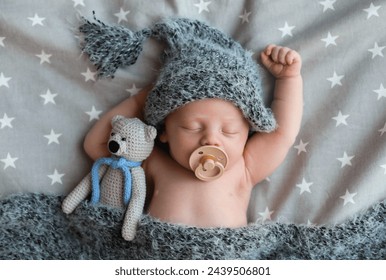 Cute newborn baby in warm hat with toy sleeping on bed, top view - Powered by Shutterstock