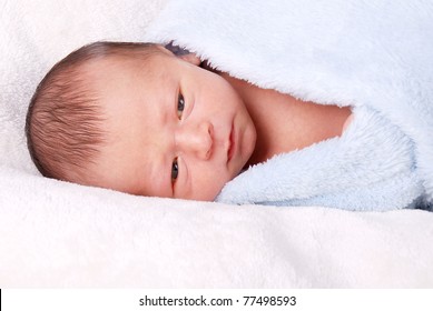 Cute Newborn Baby Wrapped Up In A Blue Blanket Wide Awake