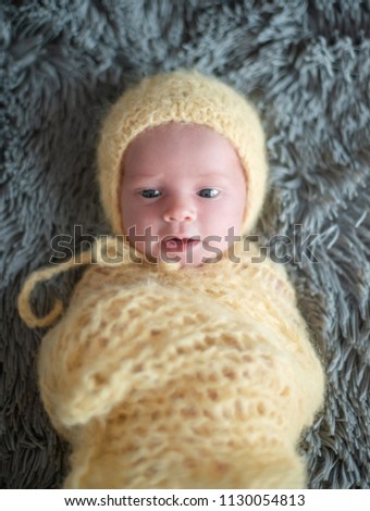 Cute newborn baby in a yellow hat