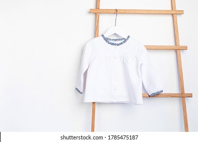 Cute Newborn Clothes Hanging On The Rack. Organic Cotton Baby Apparel Mockup.