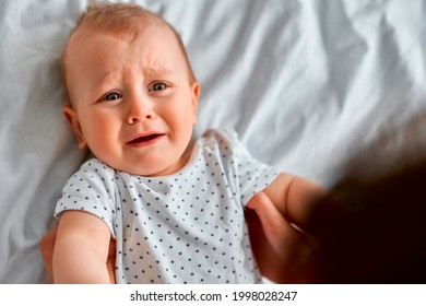 Cute Nice Little Baby Boy Crying Lying With Her Mom On Bed At Home. Sad Child Portrait.