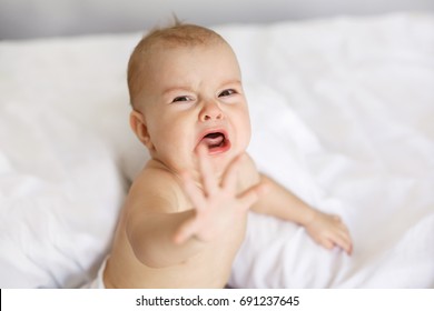 Cute nice little baby girl crying lying with her mom on bed at home. - Shutterstock ID 691237645