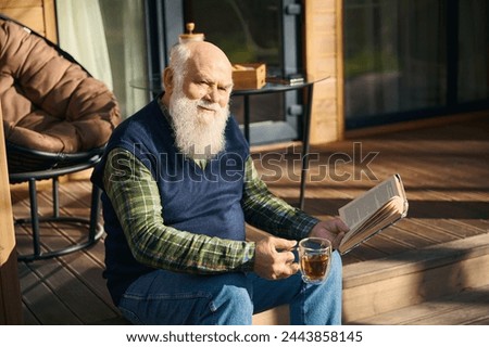Cute old man sitting with a book on the porch