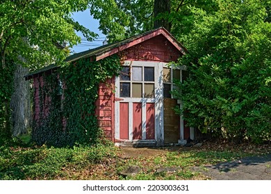 A cute old red vintage car garage in the 1940's style. With ivy growing up one side.  - Shutterstock ID 2203003631