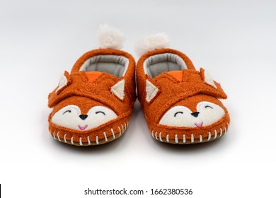 Cute Orange Fox Shaped Baby Slippers Isolated On White Background.