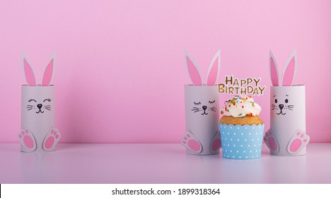 Cute Paper Rabbits From A Roll Of Toilet Paper With The Cake On His Birthday. Background For The Birthday Party. Children's Holiday