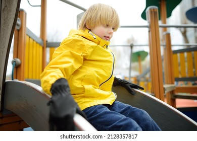 Cute perky preschooler boy having fun on outdoor playground. Spring or fall or autumn active sport leisure for kids. Modern equipment for outdoor children playground and park of entertainments - Shutterstock ID 2128357817
