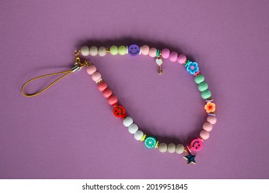 A cute phone charm made with wooden beads and charms. 