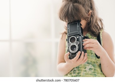 Cute photographer girl holding a vintage twin-lens reflex camera - Powered by Shutterstock