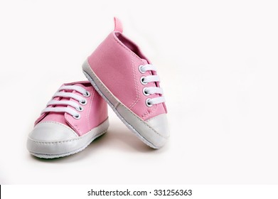 Cute pink baby girl sneakers close up on gray background