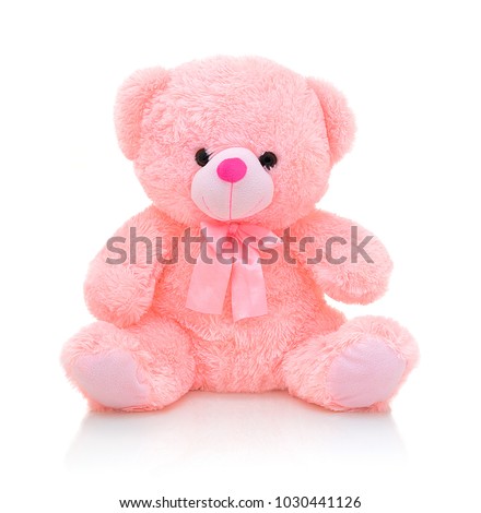 Cute pink bear doll with bow isolated on white background with shadow reflection. Playful bright pink bear sitting on white underlay. Teddy bear plush stuffed puppet with ribbon on white backdrop.