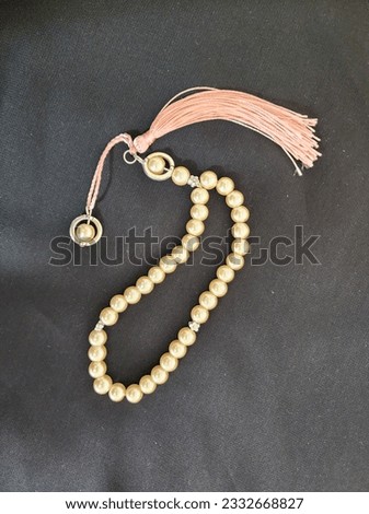 Cute pink marble beads of misbaha or rosary or chaplet or prayer beads  with pink threads in a black background