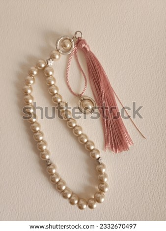 Cute pink marble beads of misbaha or rosary or chaplet or prayer beads  with pink threads in a clear white background