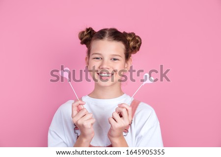 cute playful with toothy smile beautiful girl fooling around,with pink hearts on pink background